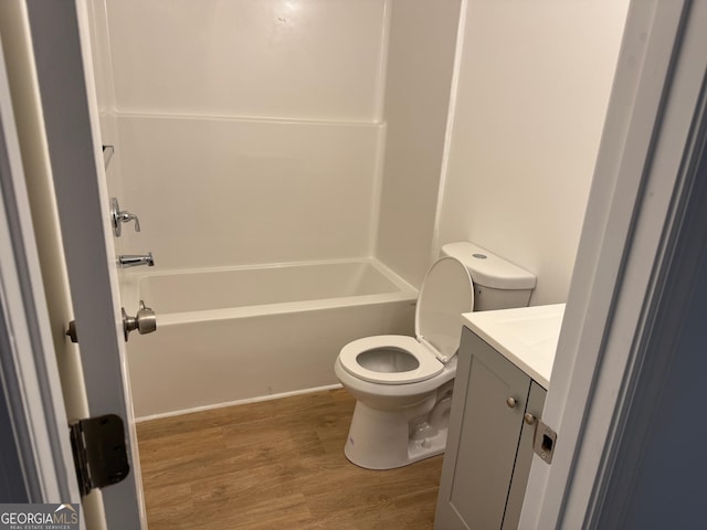 full bath featuring toilet, vanity, bathtub / shower combination, and wood finished floors