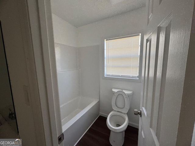 bathroom featuring baseboards, toilet, wood finished floors, and a textured ceiling