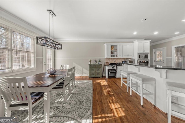 dining space with dark wood-type flooring, recessed lighting, and ornamental molding