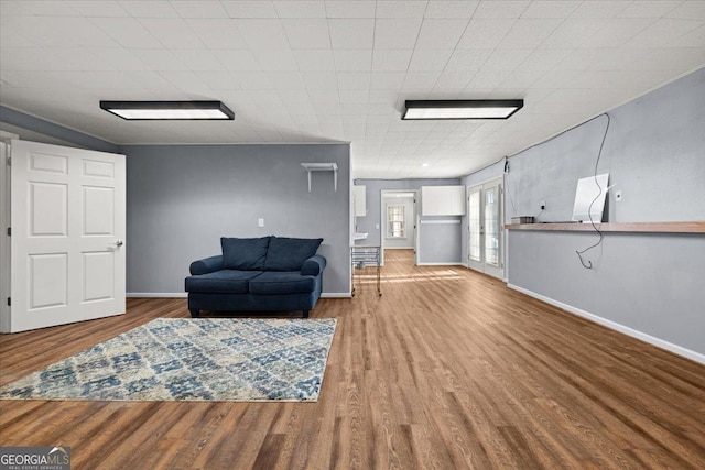 living area featuring baseboards and wood finished floors