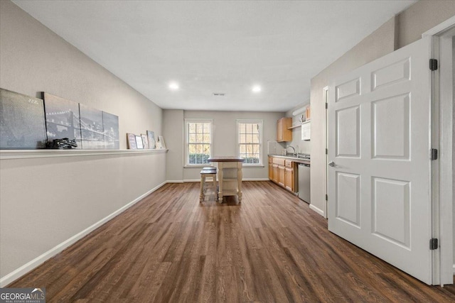 unfurnished dining area featuring dark wood finished floors and baseboards