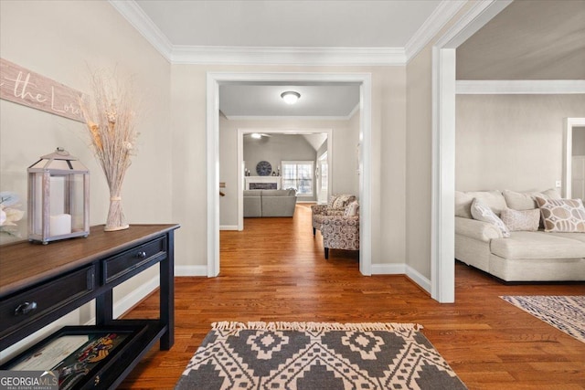 corridor with baseboards, wood finished floors, and crown molding