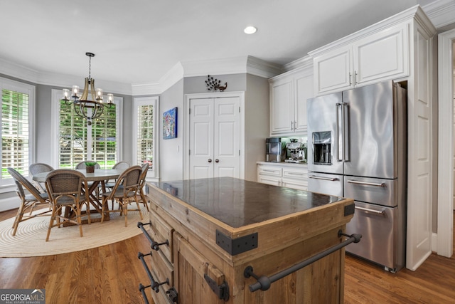 kitchen featuring a healthy amount of sunlight, dark wood finished floors, high end refrigerator, and white cabinetry