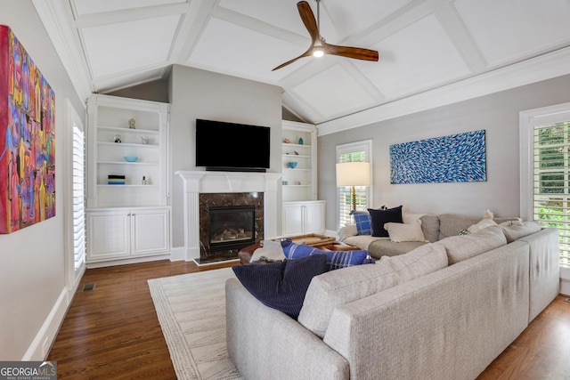 living area with built in shelves, wood finished floors, a ceiling fan, baseboards, and a fireplace