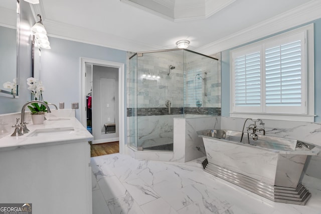 bathroom with a shower stall, a freestanding bath, crown molding, and a sink