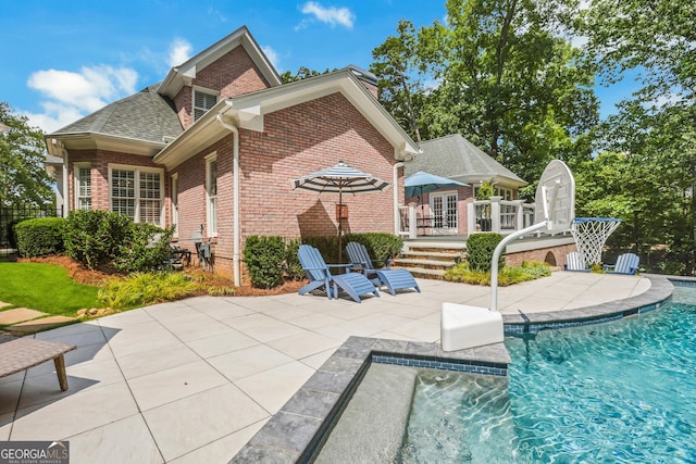 back of house featuring brick siding, a patio area, and an outdoor pool