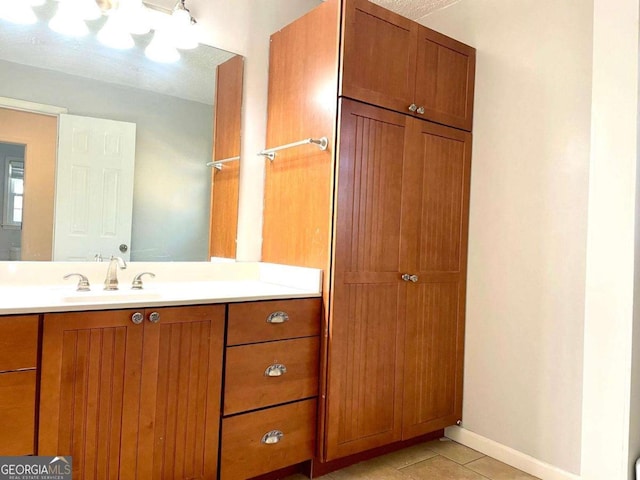 bathroom with vanity, tile patterned floors, and baseboards