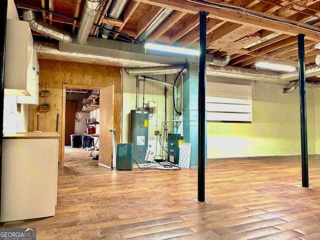 unfinished basement featuring wood finished floors and electric water heater