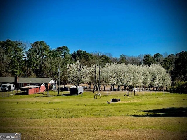 view of community with a lawn and fence