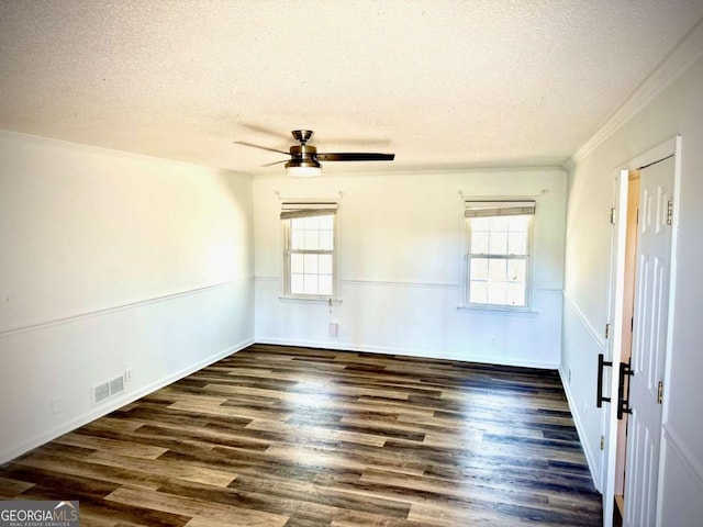 spare room with plenty of natural light, wood finished floors, and wainscoting