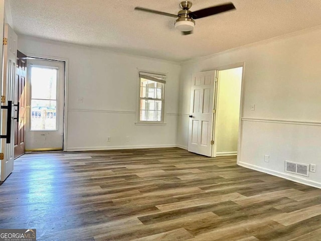 spare room with visible vents, baseboards, wood finished floors, a textured ceiling, and a ceiling fan