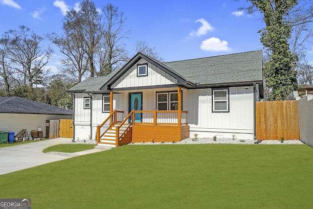 modern farmhouse style home featuring a shingled roof, a front lawn, fence, a porch, and concrete driveway