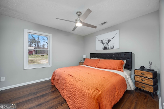 bedroom with visible vents, baseboards, ceiling fan, and dark wood finished floors