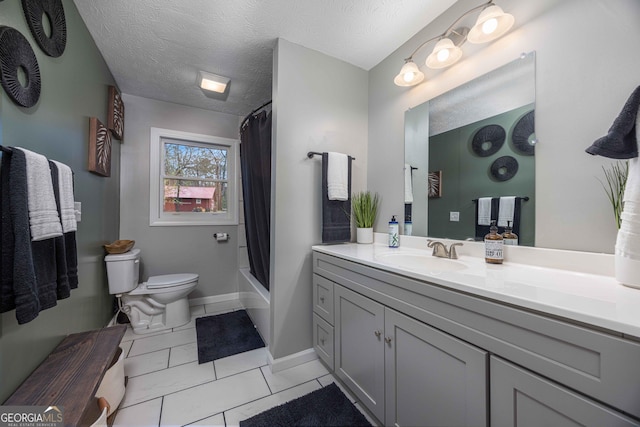 bathroom featuring vanity, tile patterned floors, toilet, baseboards, and a textured ceiling