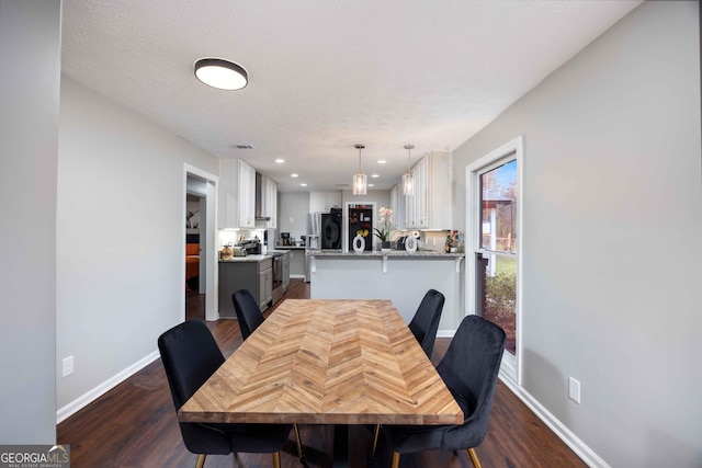 dining area with dark wood finished floors, baseboards, and recessed lighting