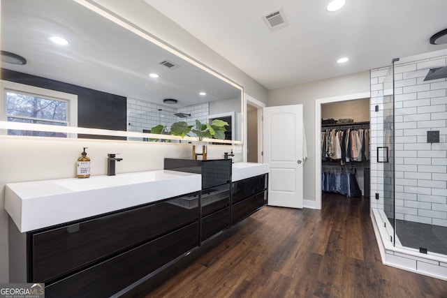 full bathroom with a stall shower, visible vents, and wood finished floors