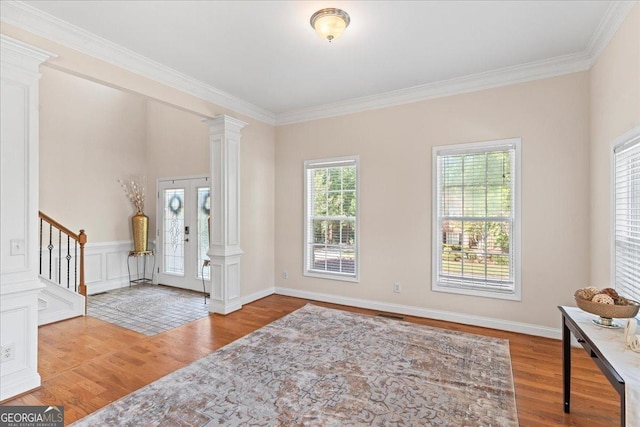 entryway featuring crown molding, stairway, wood finished floors, and ornate columns