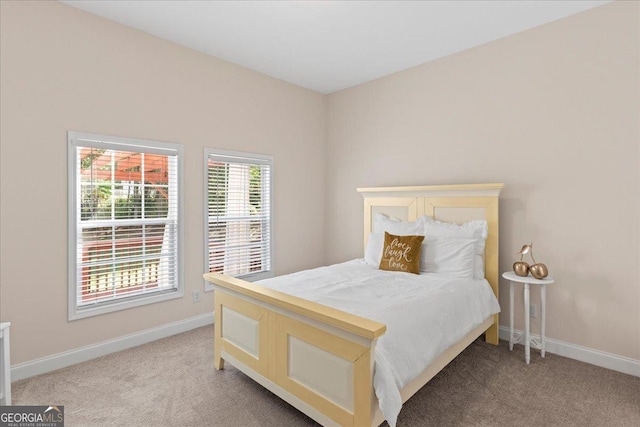 bedroom featuring light carpet and baseboards