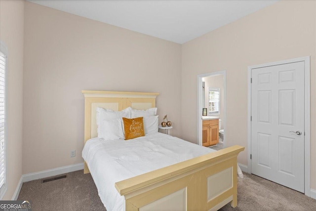 bedroom featuring visible vents, carpet flooring, connected bathroom, and baseboards