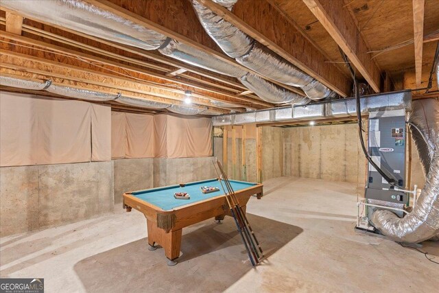 playroom with heating unit, billiards, and unfinished concrete floors