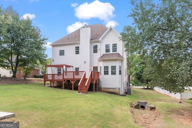 back of property with fence, a wooden deck, a chimney, stairs, and a lawn