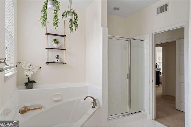 bathroom featuring a wealth of natural light, visible vents, a stall shower, and a bath