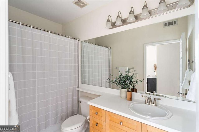 bathroom with visible vents, curtained shower, toilet, and vanity