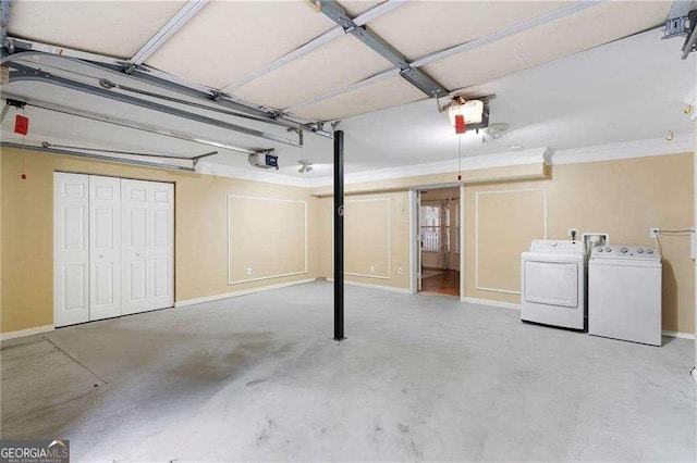 garage featuring a garage door opener, washing machine and dryer, and baseboards