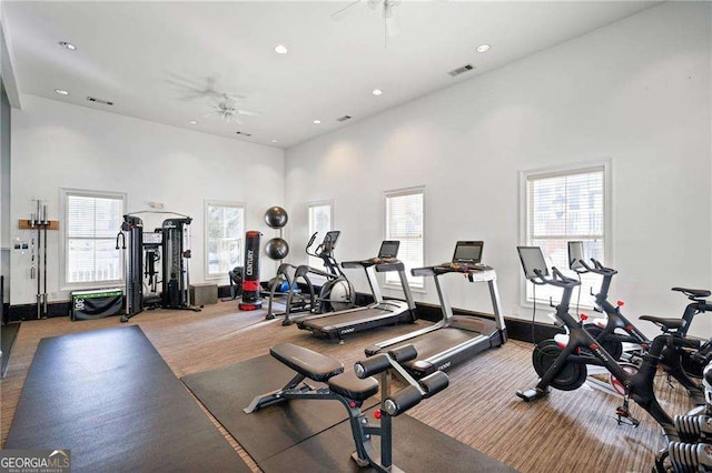 workout area with a ceiling fan, visible vents, recessed lighting, a towering ceiling, and carpet flooring