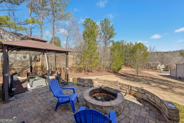 view of patio with a gazebo and an outdoor living space with a fire pit