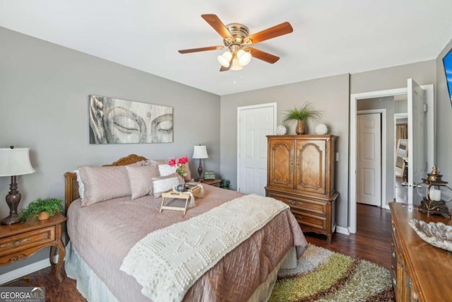 bedroom featuring ceiling fan, baseboards, and dark wood-style floors