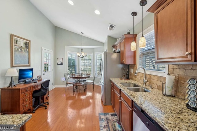 kitchen with visible vents, a sink, vaulted ceiling, appliances with stainless steel finishes, and backsplash