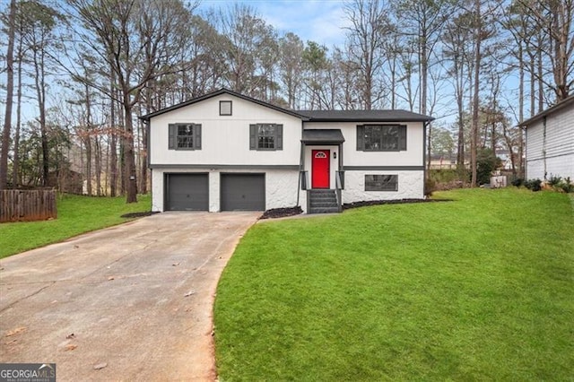 split foyer home featuring a garage, concrete driveway, and a front yard