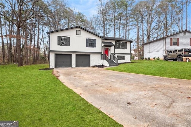 bi-level home with a garage, concrete driveway, and a front yard