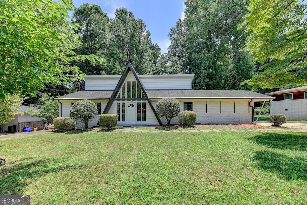 view of front of property featuring a front lawn and roof with shingles