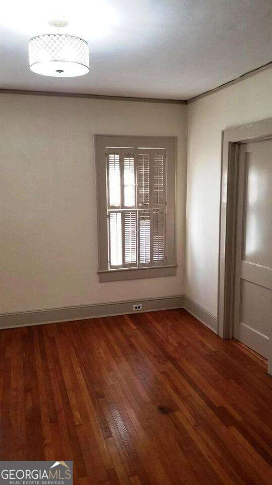 empty room with baseboards and hardwood / wood-style floors