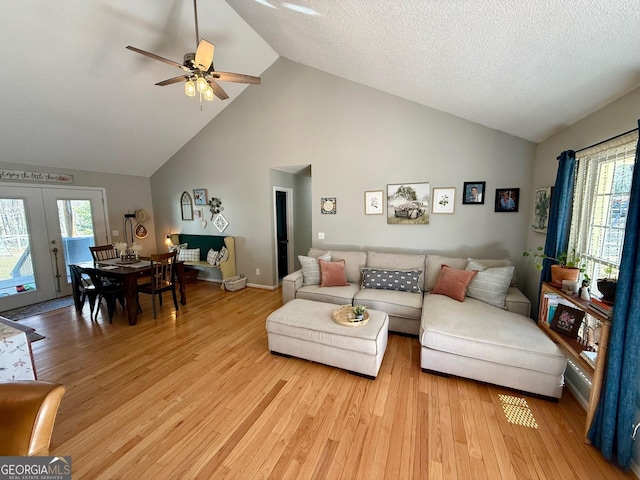 living area featuring light wood finished floors, plenty of natural light, a textured ceiling, and ceiling fan