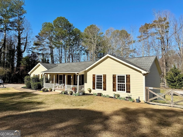 single story home with a porch, a front yard, and a shingled roof