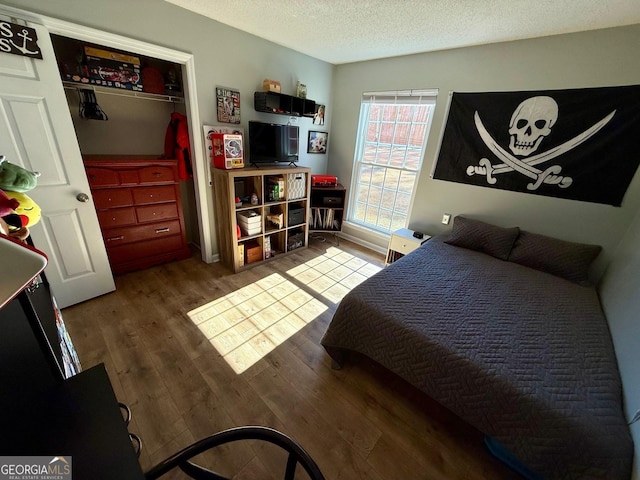 bedroom featuring a textured ceiling and wood finished floors