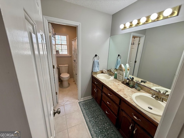 bathroom featuring tile patterned flooring, double vanity, a textured ceiling, and a sink