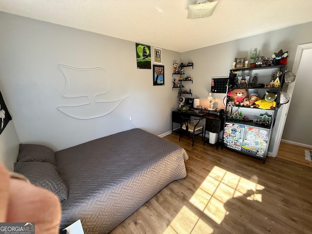 bedroom featuring baseboards and wood finished floors