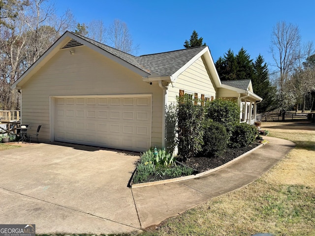 view of property exterior with concrete driveway, a shingled roof, and a garage