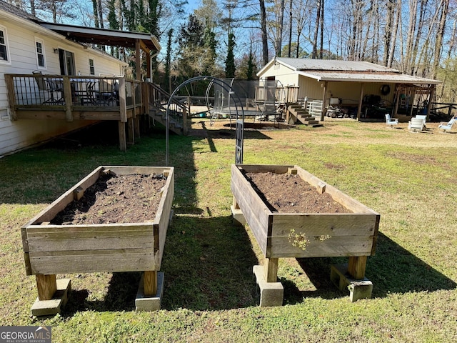 view of yard with a deck, a vegetable garden, and a trampoline