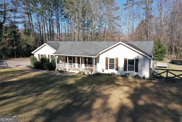 ranch-style house with a front yard, fence, covered porch, and a shingled roof