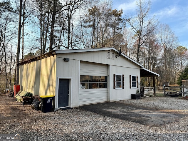 garage featuring gravel driveway and fence