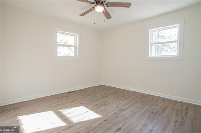 spare room with a ceiling fan, wood finished floors, and baseboards