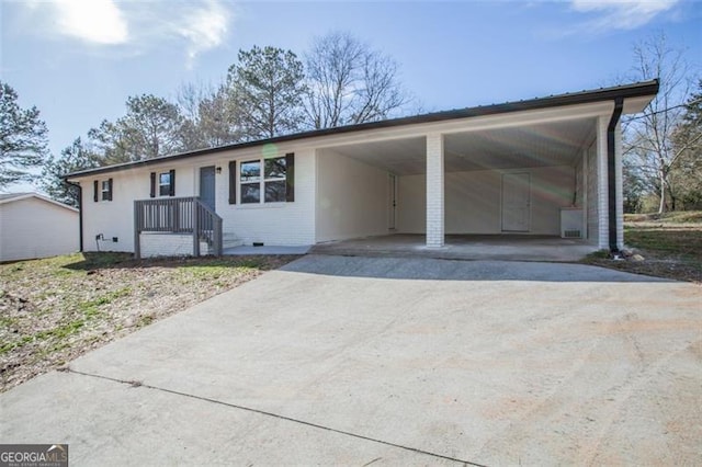 ranch-style house with brick siding, an attached carport, and concrete driveway