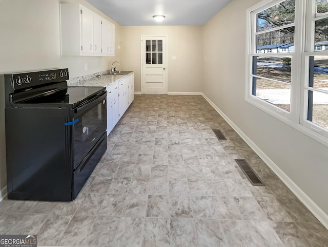 kitchen with a sink, visible vents, white cabinets, and black electric range oven