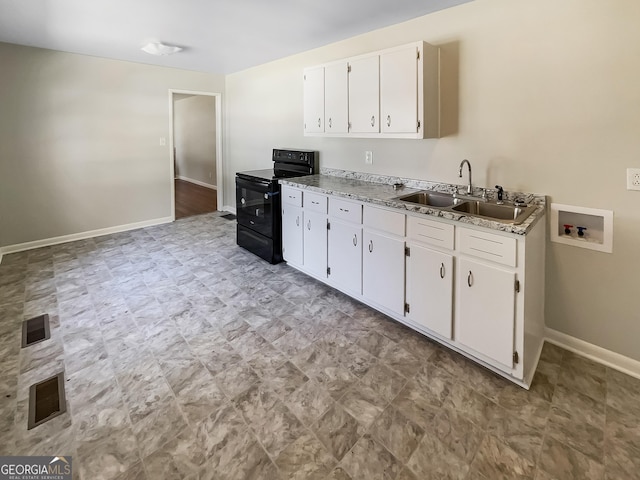 kitchen with white cabinetry, black range with electric cooktop, baseboards, and a sink