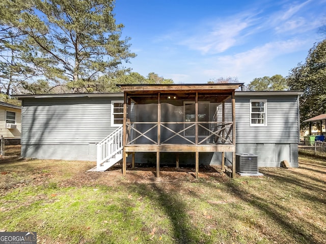 rear view of property featuring central air condition unit, a lawn, and a sunroom